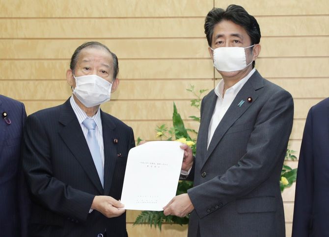 自民党の二階俊博幹事長（左）から緊急提言を受け取る安倍晋三首相＝2020年7月22日、首相官邸