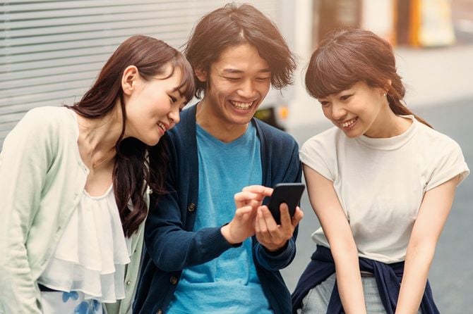 スマホを見ている若者たち