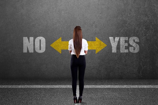 イエス、ノーと書かれた壁の前に立つ人