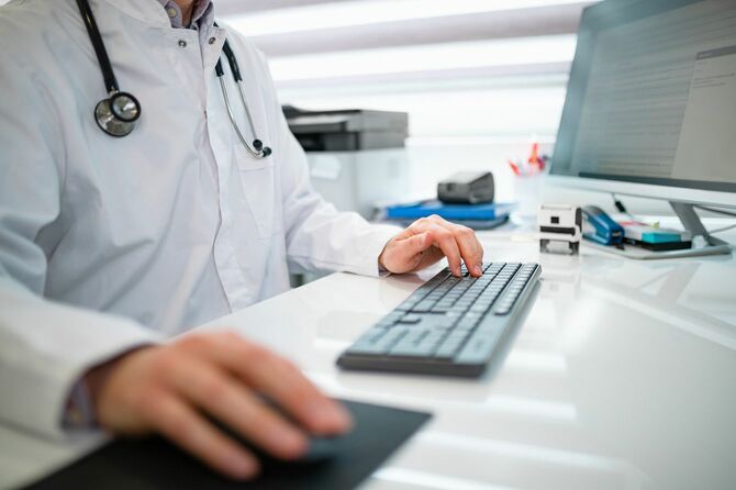 コンピューターを使用する医師