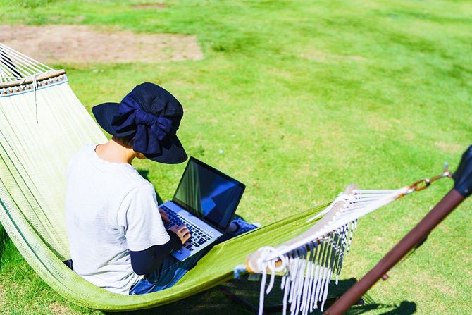 ハンモックの上でノートパソコンの操作