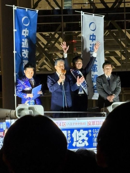 会場の「なっちゃんコール」に山口那津男氏。写真右端が枝野幸男氏。