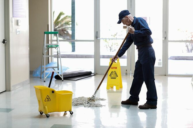 シニアアダルト管理人は、ウイルスのために床をきれいにし、消毒し続けます。