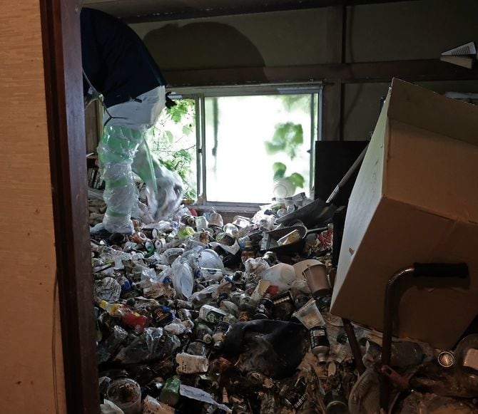 2階で作業をする様子。うずたかくゴミが積まれているため、頭を屈めないと立つこともできない。