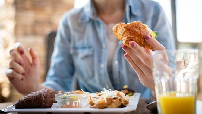レストランで朝食を食べる女性