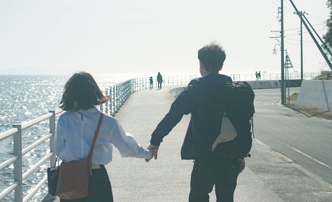 一緒に歩道を歩いているカップル