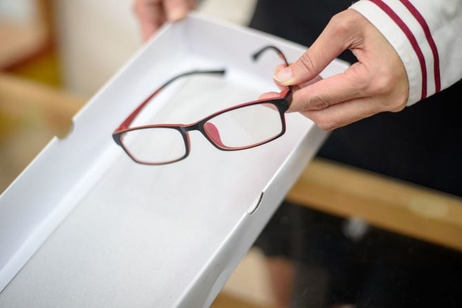 顧客に新しい眼鏡を渡す人