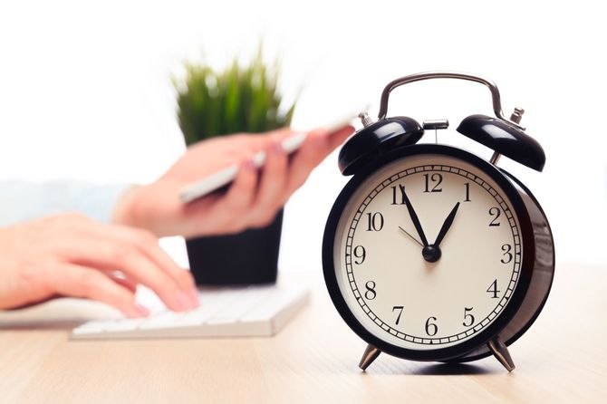 オフィスデスクに置かれた目覚まし時計