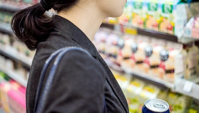 たくさんの商品を前に買い物をしている女性