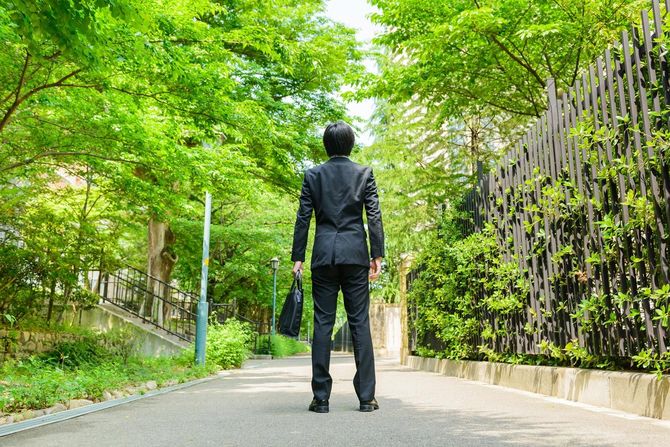新緑のなかに立つビジネスマン