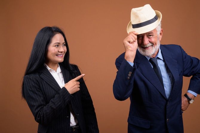 シニア男性を指さし笑顔を見せる女性