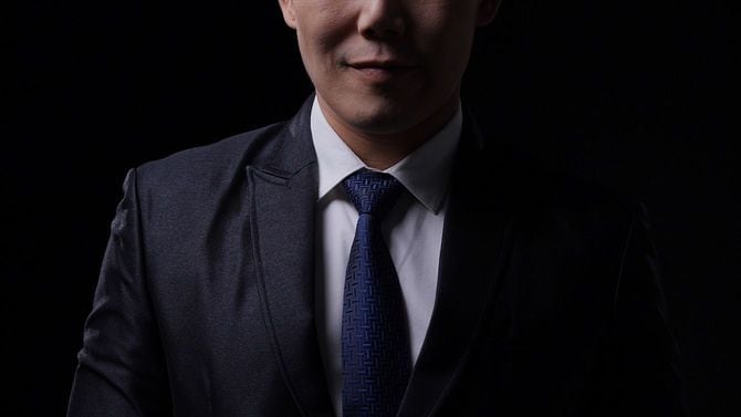 黒い背景にスーツを着た男性