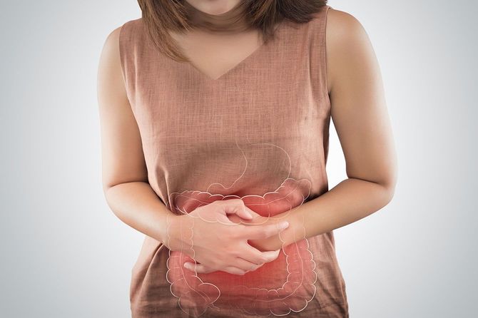 お腹を押さえて腸の不調に苦しむ女性