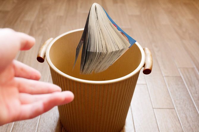 ゴミ箱に投げ込まれる古い漫画本