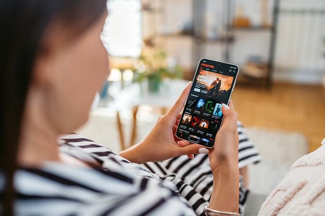 スマホで観る映画を選ぶ女性