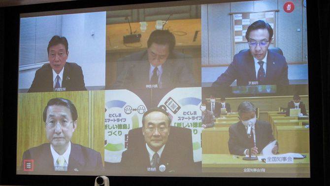 新型コロナウイルス対策をめぐり、全国知事会の飯泉嘉門会長（下中央）らとテレビ会議を開く西村康稔経済再生担当相（左上）＝2021年1月12日午後、東京都千代田区