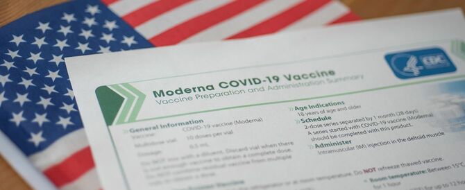 2020年12月23日。アメリカの国旗にCDCによるModerna COVID-19 Vaccineフォーム