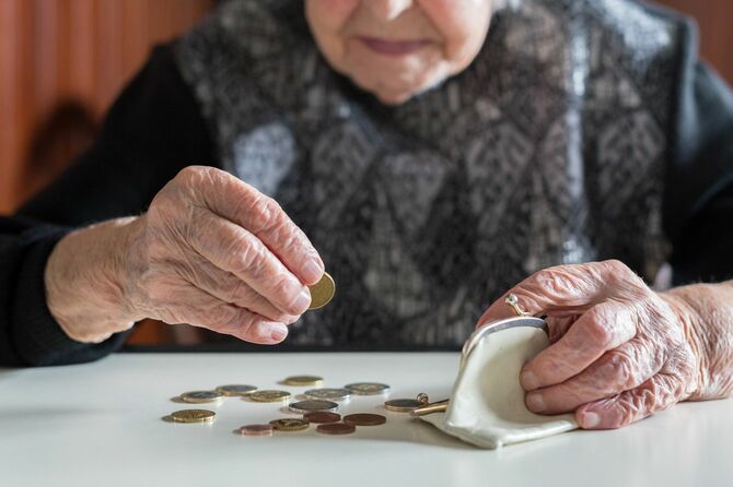 財布から出したコインを数えるシニア女性