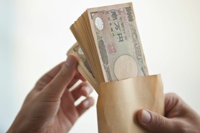 茶封筒に入った大量の一万円札の数を数える手元