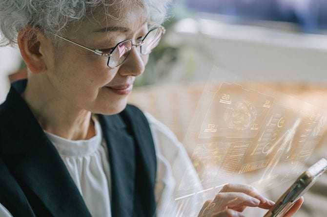 未来的なデジタルインターフェースオーバーレイを備えたスマートフォンを使用する日本人シニア女性