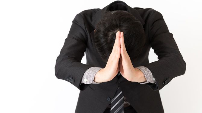 ビジネスマンが謝罪している場面