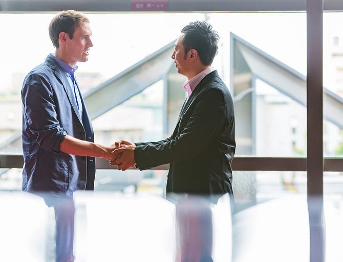 握手をする、外国人と日本人のビジネスマン