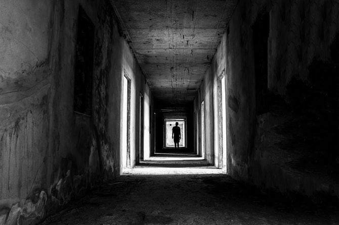 建物の薄暗い通路を歩く人