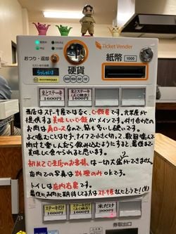 「コメトステーキ」の券売機。「当店はステーキ屋ではなく、ご飯屋です」と手書きで書かれたメッセージが目を引く