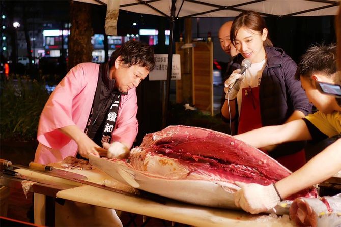 マグロの解体ショーを行う森朝奈さん(右)と父・嶢至さん(左)。