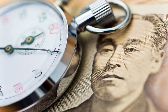 日本の通貨とストップウォッチ