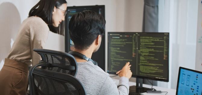 事務所でプログラミングに取り組む二人