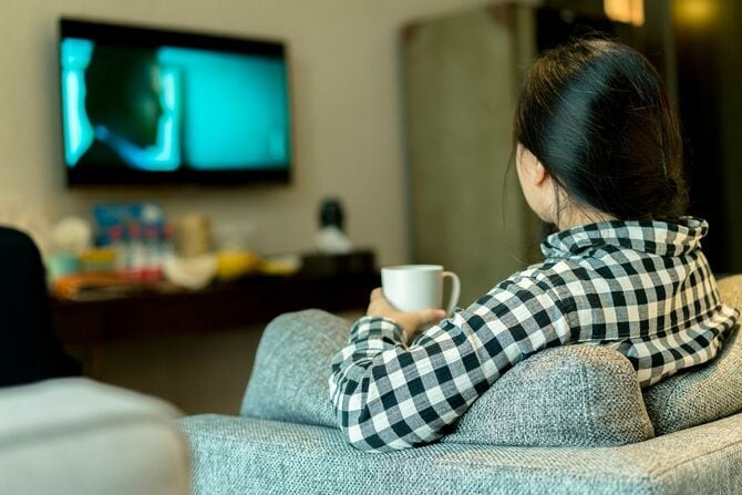 テレビを見ながら水を飲む女性