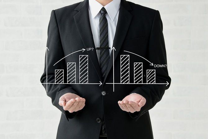 上向きと下向きのチャートを示すビジネスマン