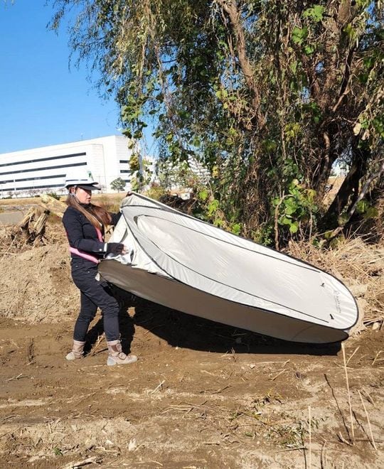 仮設トイレを使うために必要な、仕切り用の簡易テントを組み立てる東さん