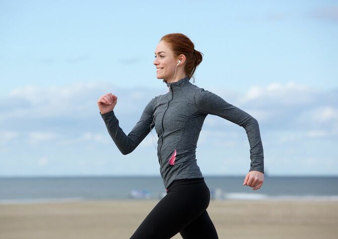 海辺でジョギングする女性