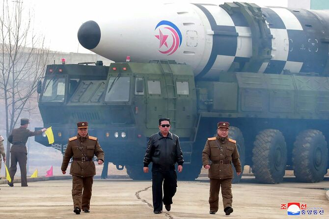 北朝鮮の金正恩委員長が、試験発射前に新型大陸間弾道ミサイル（ICBM）とする国家メディアの報道の近くを歩いている様子。北朝鮮の公式朝鮮中央通信が25日に報じた。