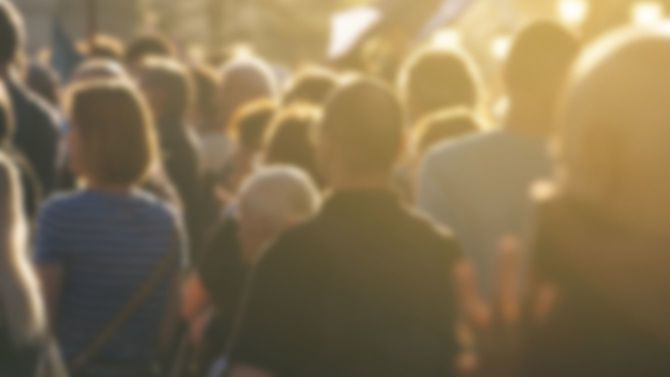 屋外で行われている政治家の演説の聴衆