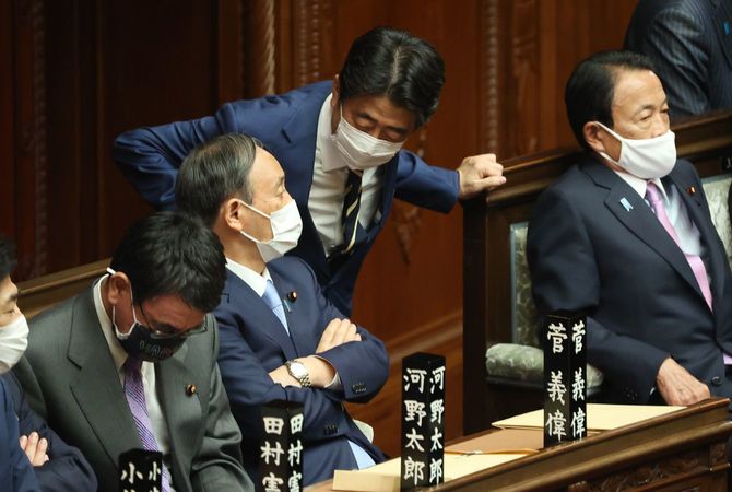 衆院本会議場で菅義偉首相（中央左）に声を掛ける安倍晋三前首相（同右）＝2021年4月1日、国会内