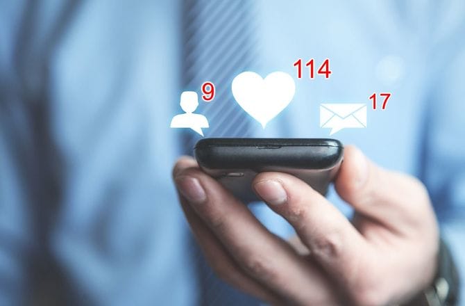 スマホを持つ手とSNSアイコン