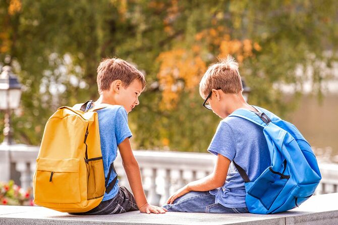ベンチに座って話をしている二人の少年