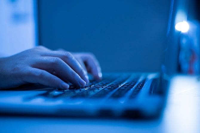 自宅で働くラップトップコンピュータを使用して男の手