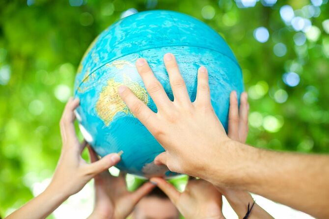地球儀を持つ人々の手