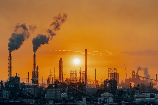 巨大な石油化学工場の背後で沈む夕日