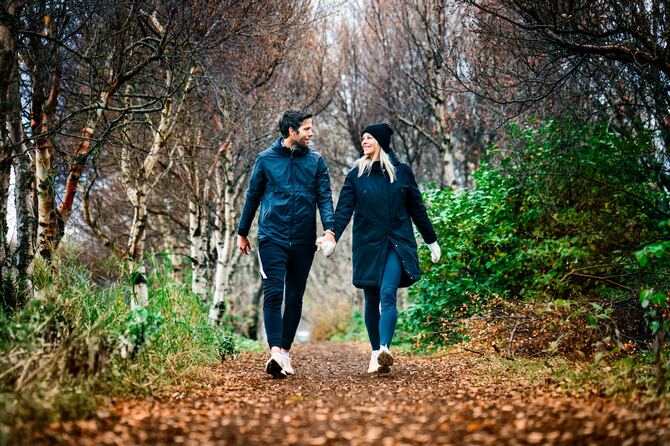 冬の公園を歩く笑顔のカップル