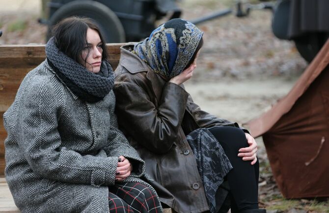 ベラルーシ、ゴメルの通りで、疲れた女性たちは寒さの中に座っている