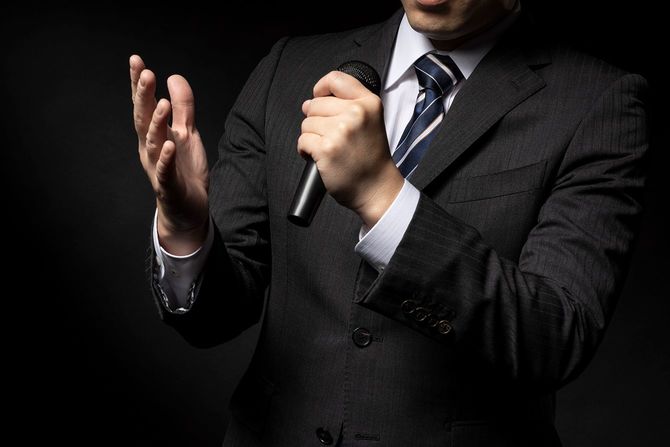 マイクで話す男性