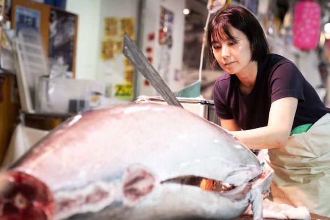 真剣な表情でマグロをさばく高橋李奈さん