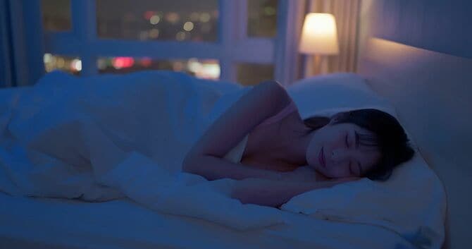 ベッドで寝る女性