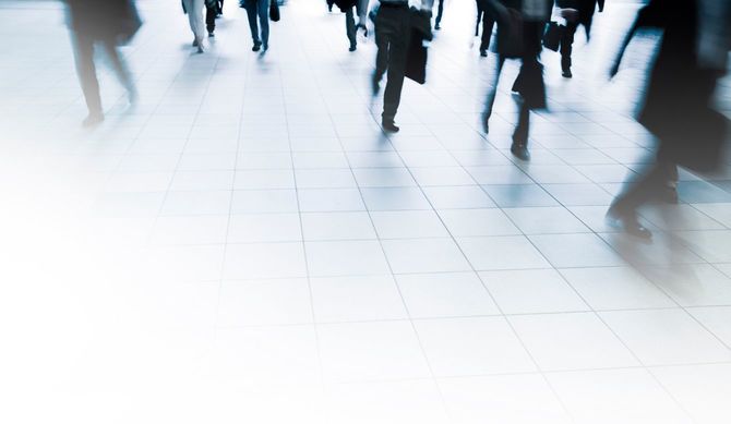 通勤時間帯に通路を足早に歩く人々の足元