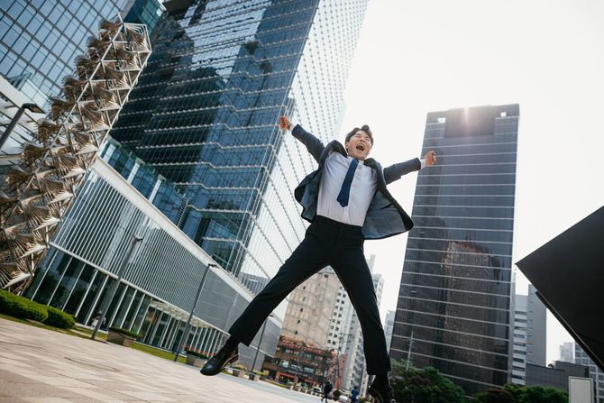 ビル街で喜ぶビジネスマン